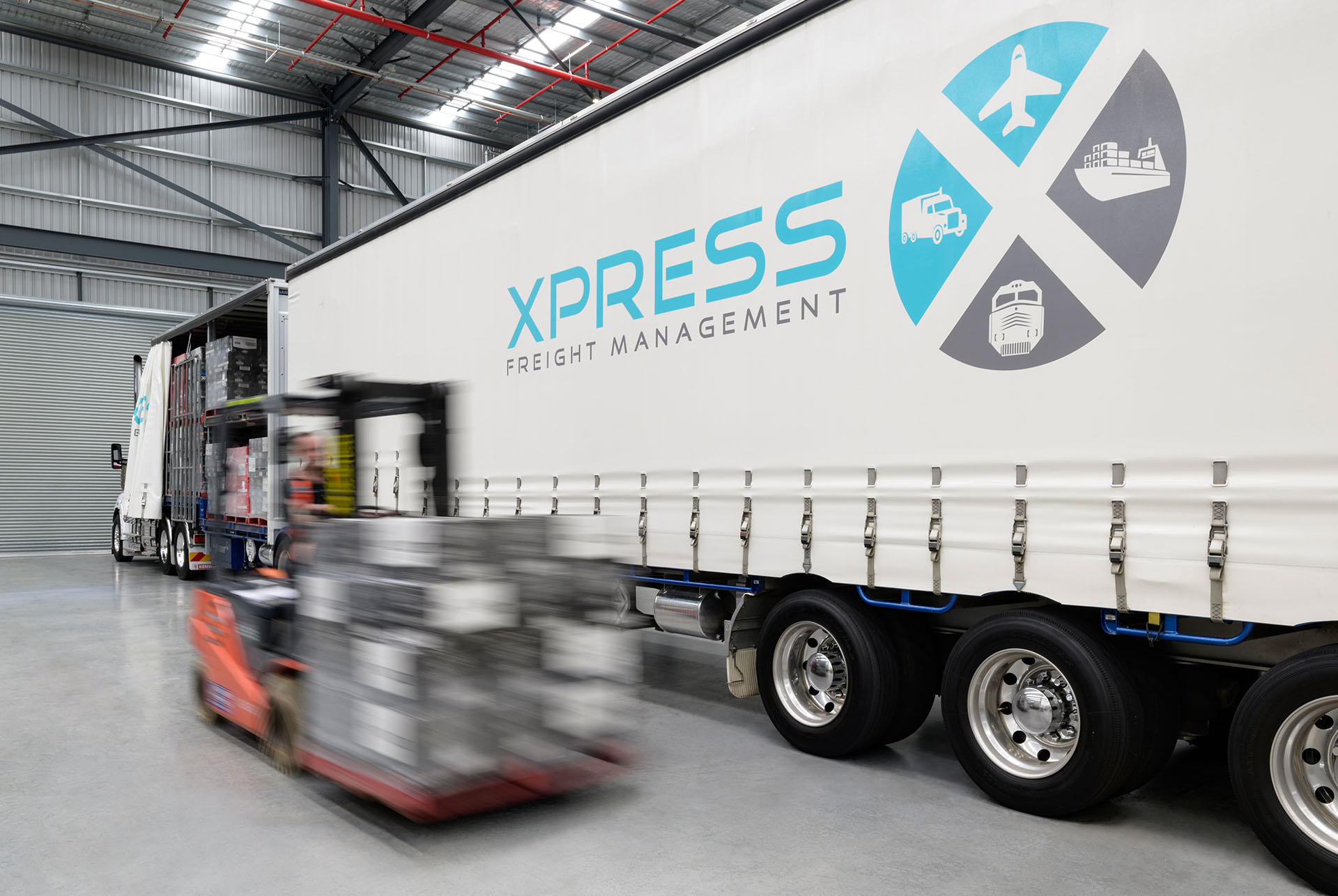 XPress Freight Management truck pallet being unloaded by a forklift inside of depot location