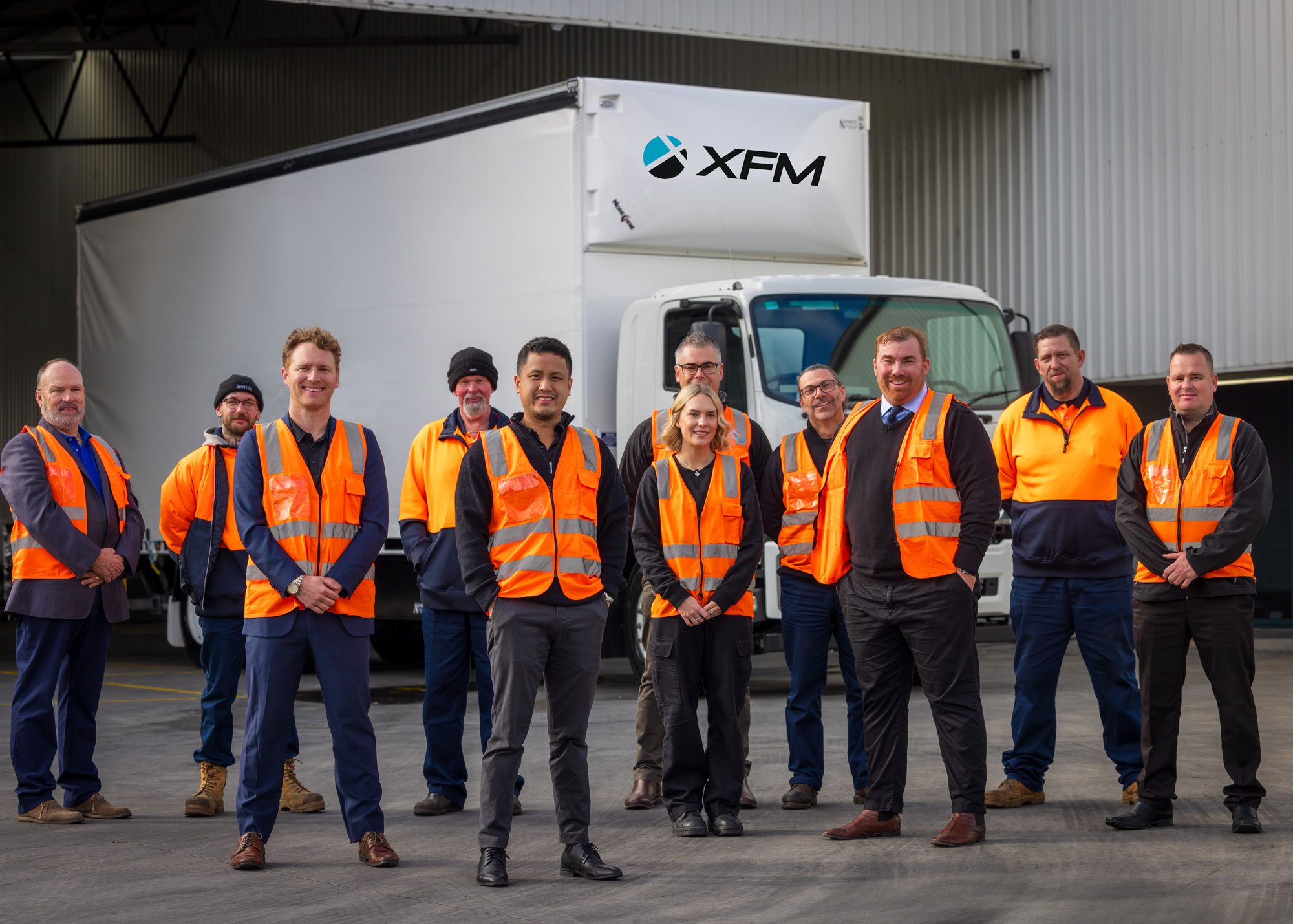 XFM logistics team standing together at an Australian freight depot.